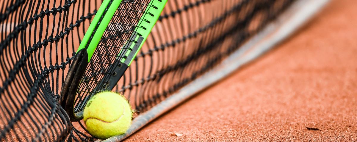 Foto von einem Tennisball im Netz und einem Schleger