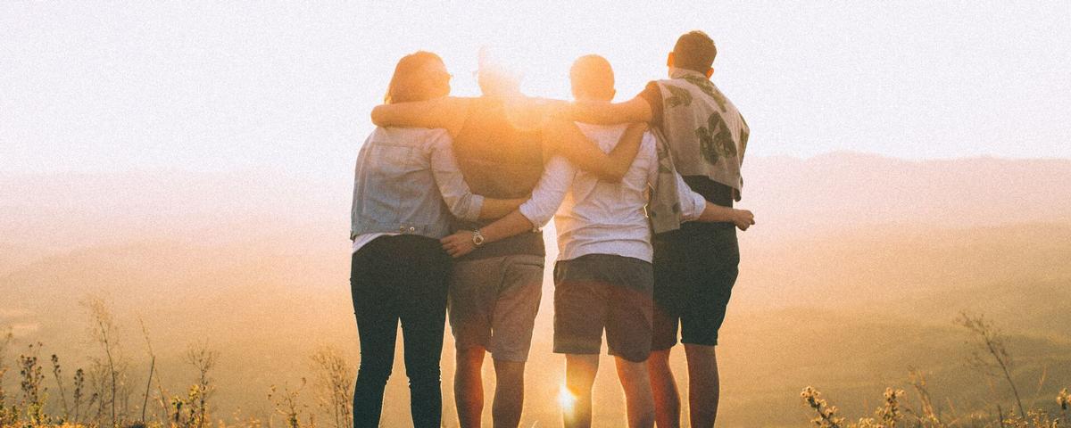 Vier vertraute Personen bei Sonnenuntergangsstimmung