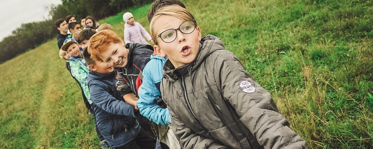 Kinder beim Seilziehen auf einer Wiese