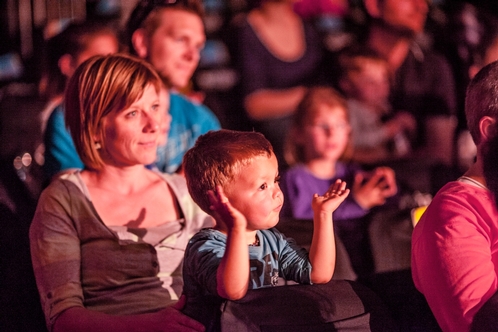 Eine Familie beim Zuschauen einer Kulturveranstaltung